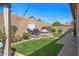 Relaxing backyard with a water feature, comfortable seating, string lights, and well-maintained landscaping at 18970 W Desert Hills Dr, Surprise, AZ 85388