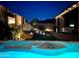 Inviting backyard with a water feature, spa and cozy patio area illuminated at twilight at 18970 W Desert Hills Dr, Surprise, AZ 85388