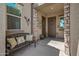 Cozy front porch featuring stone pillars, decorative wreaths, and comfortable seating for guests at 18970 W Desert Hills Dr, Surprise, AZ 85388