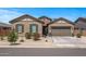 Charming single-story home featuring a stone facade, desert landscaping, and a two-car garage at 18970 W Desert Hills Dr, Surprise, AZ 85388
