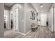 Bright hallway featuring wood-look tile floors and a cozy bench with decor at 18970 W Desert Hills Dr, Surprise, AZ 85388