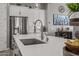 Kitchen island with quartz countertop, stainless steel sink, and modern faucet create a beautiful and functional space at 18970 W Desert Hills Dr, Surprise, AZ 85388