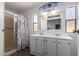 A bathroom has a large mirror above a double vanity with a glass door shower to the side at 201 S Greenfield Rd # 129, Mesa, AZ 85206