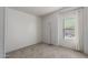 A basic bedroom has light carpet, white walls, a window with a view and a floor lamp at 201 S Greenfield Rd # 129, Mesa, AZ 85206