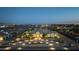 Aerial shot showcases the estate, including a circular driveway, mature landscaping, and beautiful night-time lighting at 20213 W Amelia Ave, Buckeye, AZ 85396
