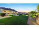 Beautiful backyard with artificial grass, pool, outdoor kitchen, and covered patio, perfect for entertaining at 20213 W Amelia Ave, Buckeye, AZ 85396