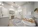 Bright bathroom with dual vanities, stylish rug, soaking tub, and elegant light fixtures at 20213 W Amelia Ave, Buckeye, AZ 85396
