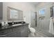 Bathroom featuring a granite vanity and glass enclosed shower with tiled accent wall at 20213 W Amelia Ave, Buckeye, AZ 85396
