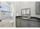 Bathroom boasts granite counters, gray cabinetry, and a shower/tub combo with glass doors at 20213 W Amelia Ave, Buckeye, AZ 85396