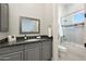 Bright bathroom with a gray vanity, framed mirror, and glass shower with tiled accent at 20213 W Amelia Ave, Buckeye, AZ 85396