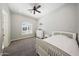 Cozy bedroom with a ceiling fan, plush carpeting, and a bright window at 20213 W Amelia Ave, Buckeye, AZ 85396