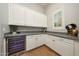 Bright butler's pantry featuring granite countertops, white cabinetry and a built-in wine fridge at 20213 W Amelia Ave, Buckeye, AZ 85396
