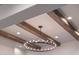 Detailed shot of a ceiling showing wood beams, recessed lighting, and a decorative chandelier at 20213 W Amelia Ave, Buckeye, AZ 85396