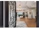 Grand foyer with ornate iron door, chandelier, and views into the open-concept living spaces at 20213 W Amelia Ave, Buckeye, AZ 85396