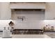 Close-up on stainless steel stove with white tile backsplash and pot filler at 20213 W Amelia Ave, Buckeye, AZ 85396