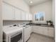 Laundry room featuring granite counters, plenty of storage, sink, and modern appliances at 20213 W Amelia Ave, Buckeye, AZ 85396