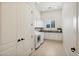 Bright laundry room featuring white cabinets, tile floors, and modern appliances at 20213 W Amelia Ave, Buckeye, AZ 85396