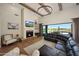 Living room featuring a fireplace, vaulted ceilings with wooden beams, and backyard views through sliding glass doors at 20213 W Amelia Ave, Buckeye, AZ 85396