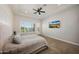 Bright main bedroom with large window, ceiling fan, and modern decor at 20213 W Amelia Ave, Buckeye, AZ 85396