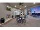 Covered patio featuring an outdoor fireplace, mounted TV, and outdoor dining at 20213 W Amelia Ave, Buckeye, AZ 85396