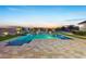 Luxurious pool area with travertine decking, waterfall feature, sports-equipment and ample space for relaxation at 20213 W Amelia Ave, Buckeye, AZ 85396