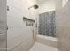 Modern shower features stone-look tile, a built-in bench, and a convenient niche for toiletries at 20213 W Amelia Ave, Buckeye, AZ 85396