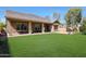 Lush backyard features a cozy patio, a dining space, and green grass perfect for outdoor relaxation at 20959 W Western Dr, Buckeye, AZ 85396