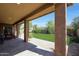 Covered patio overlooks backyard with paved patio, green grass, privacy walls and desert landscaping at 20959 W Western Dr, Buckeye, AZ 85396