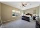 Spacious bedroom boasts a ceiling fan, large window, and elegant wood furniture at 20959 W Western Dr, Buckeye, AZ 85396