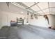 Spacious garage featuring a concrete floor and storage shelving offers ample parking and organizational space at 20959 W Western Dr, Buckeye, AZ 85396