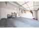Spacious garage featuring a concrete floor and storage shelving offers ample parking and organizational space at 20959 W Western Dr, Buckeye, AZ 85396