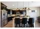 Kitchen featuring dark cabinets, granite countertops, stainless steel appliances, a kitchen island with seating and pendant lighting at 20959 W Western Dr, Buckeye, AZ 85396