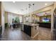 Open kitchen with dark cabinets, an island with seating, granite countertops, and an adjacent dining and living area at 20959 W Western Dr, Buckeye, AZ 85396