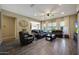 Bright and open living room featuring a wood-look accent wall, modern lighting, and comfortable leather seating at 20959 W Western Dr, Buckeye, AZ 85396