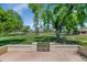 This backyard features mature trees, lush lawn, and a decorative brick and iron gate at 21222 N Aurora Dr, Sun City West, AZ 85375