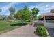 This backyard features a large, manicured lawn, mature trees, and a patio at 21222 N Aurora Dr, Sun City West, AZ 85375