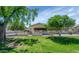 Charming single-story home featuring a well-manicured lawn and mature trees, creating a welcoming curb appeal at 21222 N Aurora Dr, Sun City West, AZ 85375