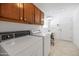 The laundry room features tile flooring, a washer and dryer, desk, and ample storage space at 21222 N Aurora Dr, Sun City West, AZ 85375