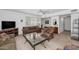 Bright living room featuring comfortable seating, a large TV, and plantation shutters for a modern look at 21222 N Aurora Dr, Sun City West, AZ 85375