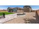 Backyard with fire pit, gravel, block patio, and artificial grass, with view of the home's exterior at 22386 N Daniel Dr, Maricopa, AZ 85138