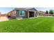 Large backyard with artificial grass, a covered patio, and stone paver accents at 22386 N Daniel Dr, Maricopa, AZ 85138