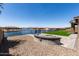 Beautiful backyard with a fire pit, gravel area, artificial grass, and waterfront views at 22386 N Daniel Dr, Maricopa, AZ 85138