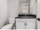 Powder room featuring a black countertop vanity with a white sink and a decorative mirror at 22386 N Daniel Dr, Maricopa, AZ 85138