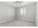 Neutral bedroom featuring gray carpet, a ceiling fan, and a window for natural light at 22386 N Daniel Dr, Maricopa, AZ 85138