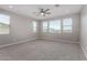 Bright bedroom features soft carpet, neutral walls, ample natural light, and ceiling fan for comfortable living at 22386 N Daniel Dr, Maricopa, AZ 85138