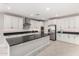 Bright, spacious kitchen with white cabinets, stainless appliances, and an island with black countertops at 22386 N Daniel Dr, Maricopa, AZ 85138