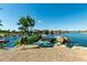 Beautiful water feature with rocks and greenery in a neighborhood canal, enhancing community aesthetics at 22386 N Daniel Dr, Maricopa, AZ 85138
