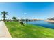 Picturesque waterfront view with a bench, palm trees, and a serene canal, creating a relaxing outdoor space at 22386 N Daniel Dr, Maricopa, AZ 85138