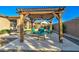 An outdoor patio featuring a wooden pergola and elegant stone flooring with comfortable seating perfect for relaxation at 22601 E Via Las Brisas --, Queen Creek, AZ 85142