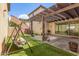 Inviting backyard features a pergola, artificial turf, and cozy seating, perfect for outdoor relaxation and entertainment at 2435 N Riley Rd, Buckeye, AZ 85396